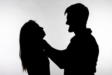 Domestic violence and abuse concept - Silhouette of a man asphyxiating a woman