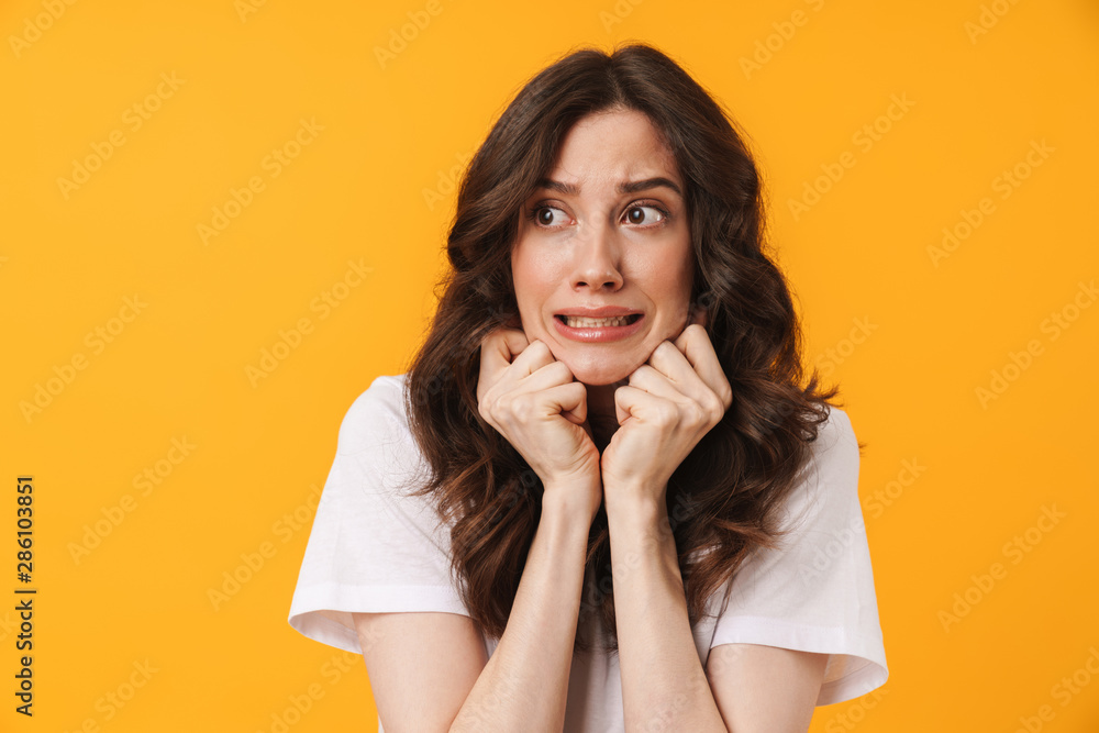 Wall mural image of nervous woman with long dark hair frowning and expressing fear