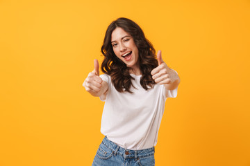 Fototapeta Image of beautiful brunette woman wearing casual clothes winking and showing thumbs up at camera obraz