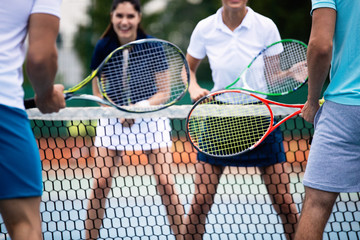 Fit happy poeple playing tennis together. Sport concept