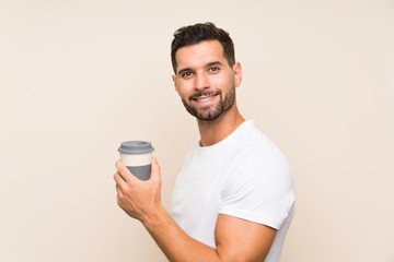 Handsome man over isolated background holding a take away coffee