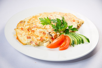 fried eggs and omelet with vegetables on a white background