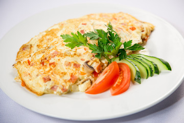 fried eggs and omelet with vegetables on a white background