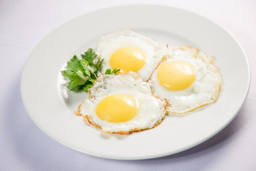 fried eggs and omelet with vegetables on a white background