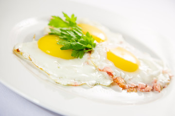 fried eggs and omelet with vegetables on a white background