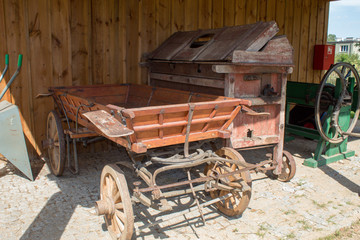 Samples of old agricultural equipment and vehicles, a grain mill and a cart made of wood and metal from rural Europeans.