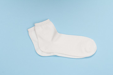 Pair of white women socks on blue background.