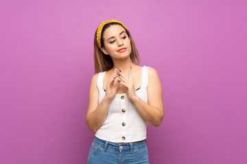 Pretty young woman over isolated purple wall scheming something