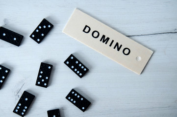 Closeup scattered dominoes on a gray, wooden table. Board game.
