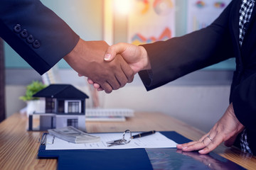 Asian Businessman estate agent shaking hands with his customer after contract signature.,concept Real estate agent.