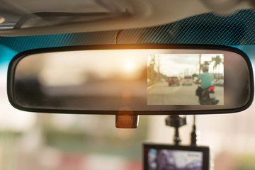 Close up car on highway at sunset, with video recorder next to a rear view mirror,video recorder...