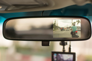 Close up car on highway at sunset, with video recorder next to a rear view mirror,video recorder...