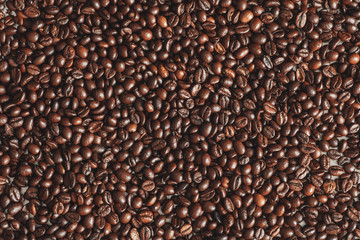 Fresh roasted brown coffee beans, top view of seeds texture as food background for design, macro photo