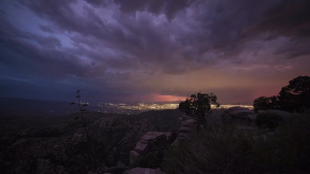 Time lapse of storms and lightning over a city at dusk