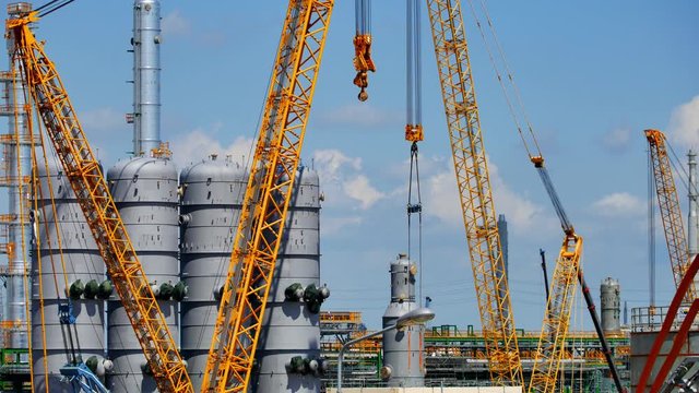 Under construction of Refinery tower and production area in oil and gas petroleum plant with vertical heavy crane