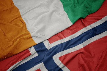 waving colorful flag of norway and national flag of cote divoire.