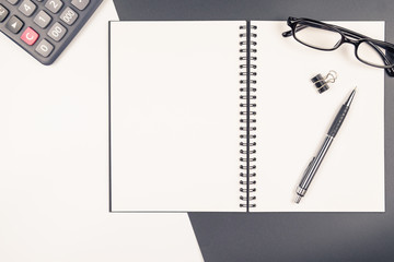 Top view of  blank notebook and stationery on black and white background