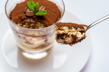 Spoon full of Classic tiramisu dessert on white background with clipping path