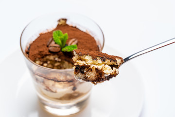 Spoon full of Classic tiramisu dessert on white background with clipping path