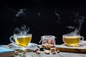 The steam from tea in cup on wood background, preparing hot tea,hot food and healthy meal concept