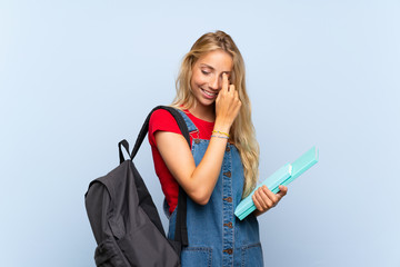 Young blonde student woman over isolated blue wall laughing