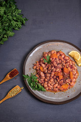 kidney bean with lemon, parsley, pepper in grey plate on isolated dark background