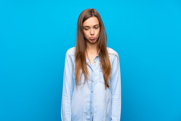 Young woman over isolated blue background with sad and depressed expression