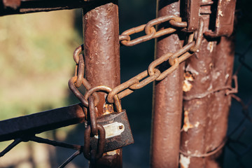 padlock locked on rustic door with chain outdoors