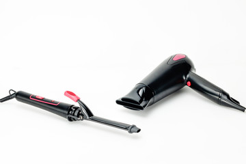 Hair iron and dryer on white mat background with copy space