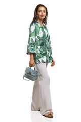Full shot of a young chestnut European lady dressed in white casual trousers, loose jacket with...