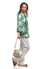 Full shot of a young chestnut European lady dressed in white casual trousers, loose jacket with...