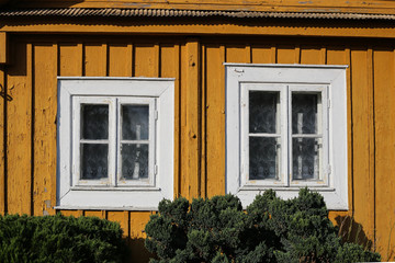 Wooden yellow windows. Part of typical house in Lithuania, Trakai. Antique old house with yellow old wood