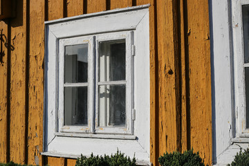 Obraz premium Yellow window wooden. Part of typical house in Lithuania, Trakai. Antique old house with yellow old wood