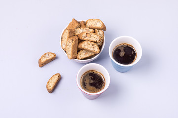 Italian Almond Biscuit Biscotti or Cantuccini in a White Bowl Tasty Italian Dessert and Two Cup Of Coffee Top View Blue Background