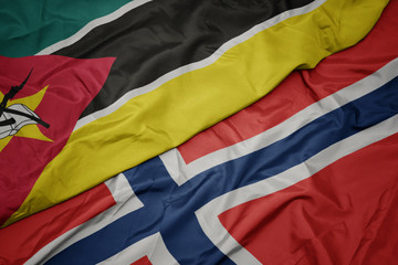 waving colorful flag of norway and national flag of mozambique.
