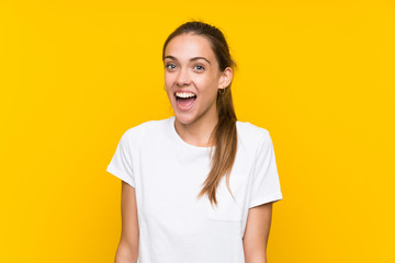 Young woman over isolated yellow background with surprise facial expression