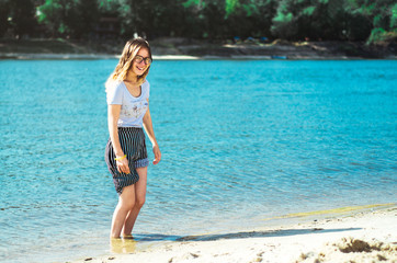 young, beautiful girl resting on the sun at the river