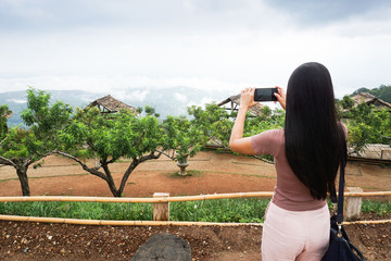 Female tourist is taking photo view of blue sky at Mon Cham, Chiang Mai, Thailand.