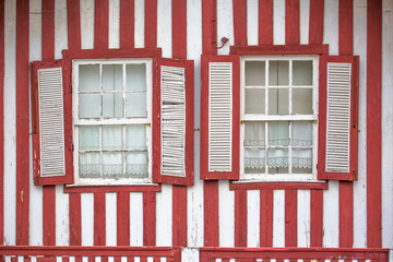 Detailed view of front facade windows of typical Costa Nova beach house, colorful striped wooden beach houses