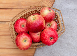 Red apples in a wicker basket on the table.