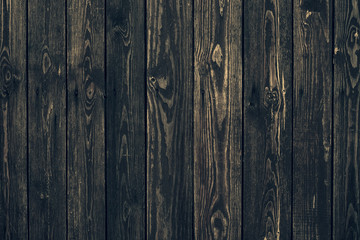Dark shabby wooden fence with nails. Texture of black planks. Old wood brown boards. Vintage timber background. Natural pattern of hurdwood.