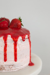 Obraz na płótnie Canvas Small fresh strawberry cake with strawberry glaze, three tier cake, white background, copy space