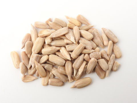 Top view of a pile of natural shelled organic sunflower seeds isolated on white background. It often eaten as a snack.  The seeds contain vitamin E. Food and snack concept. With copy space.