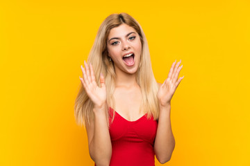 Teenager girl over isolated yellow background with surprise facial expression