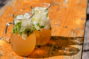 two mugs with mojito on wooden table
