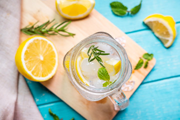 Refreshing lemonade in glass with lemon on wooden table