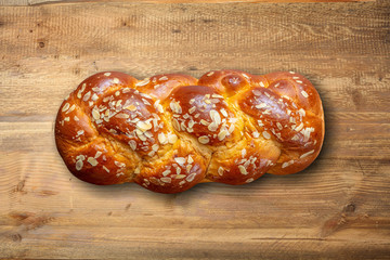 Easter bread, greek tsoureki braid on wood, top view.