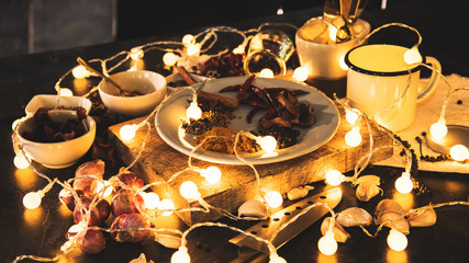 concept arrangement spices with Fresh organic vegetables with LED light string on dark wooden background. Healthy food herbs Spices for use as cooking ingredients.