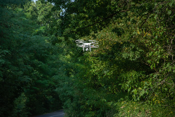 White drone flying over the forest