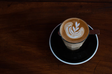 Close up hot Latte with Latte art place on wood table.